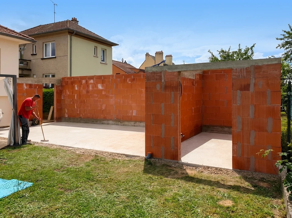 Chantier de construction extérieur avec ouvriers installant une poutre métallique sur structure échafaudage