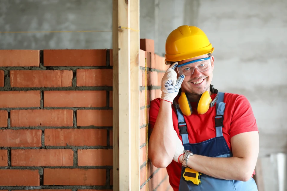 Vue latérale des charpentiers d'adultes moyens travaillant sur le chantier de construction