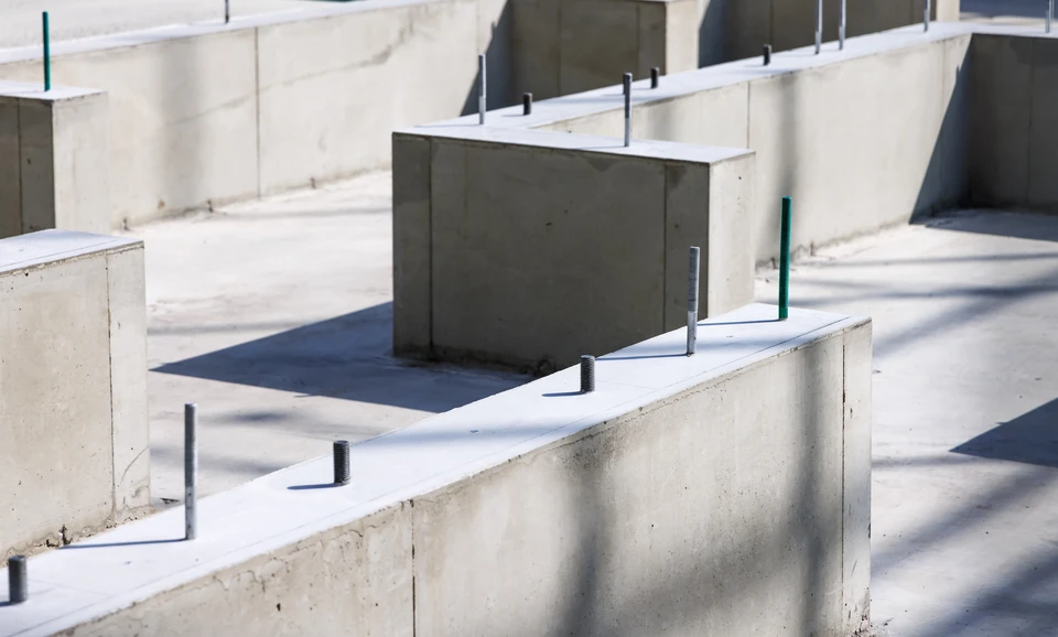 Extérieur d'un bâtiment résidentiel montrant des fissures importantes dans un mur de briques rouges avec joints de mortier gris